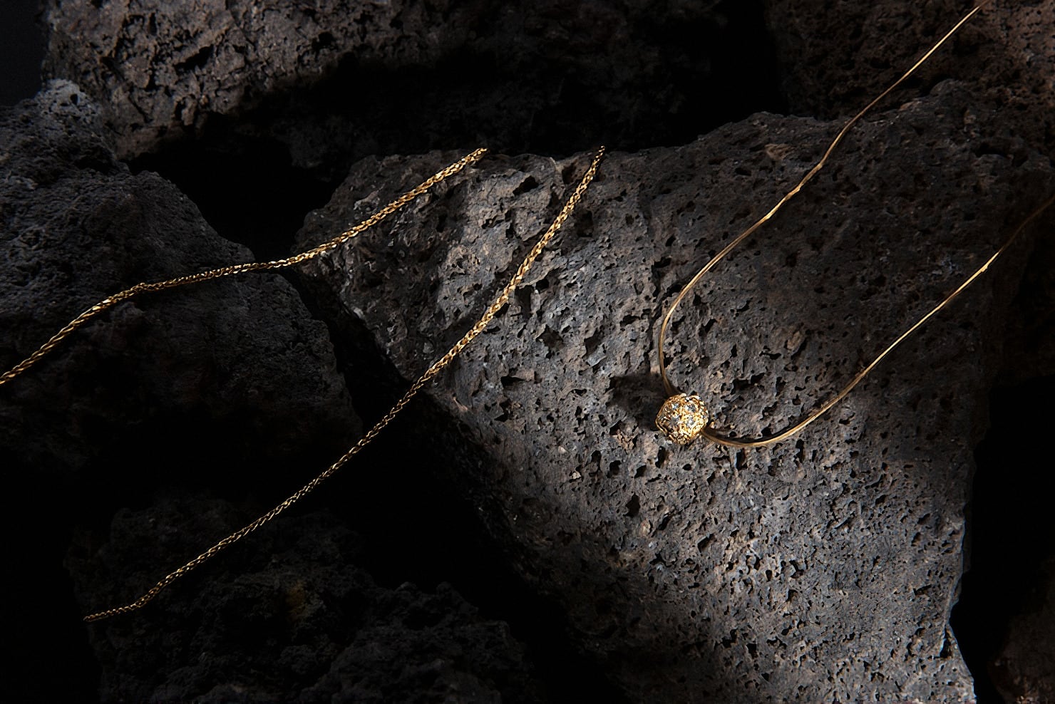 A gold chain on dark stone